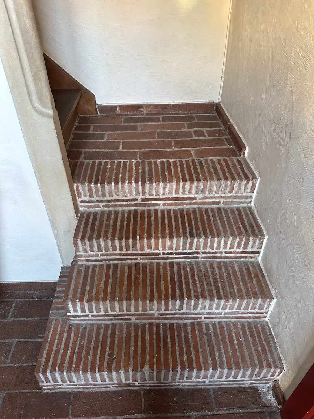 De bakstenen trap met witte voegen in de inkomhal