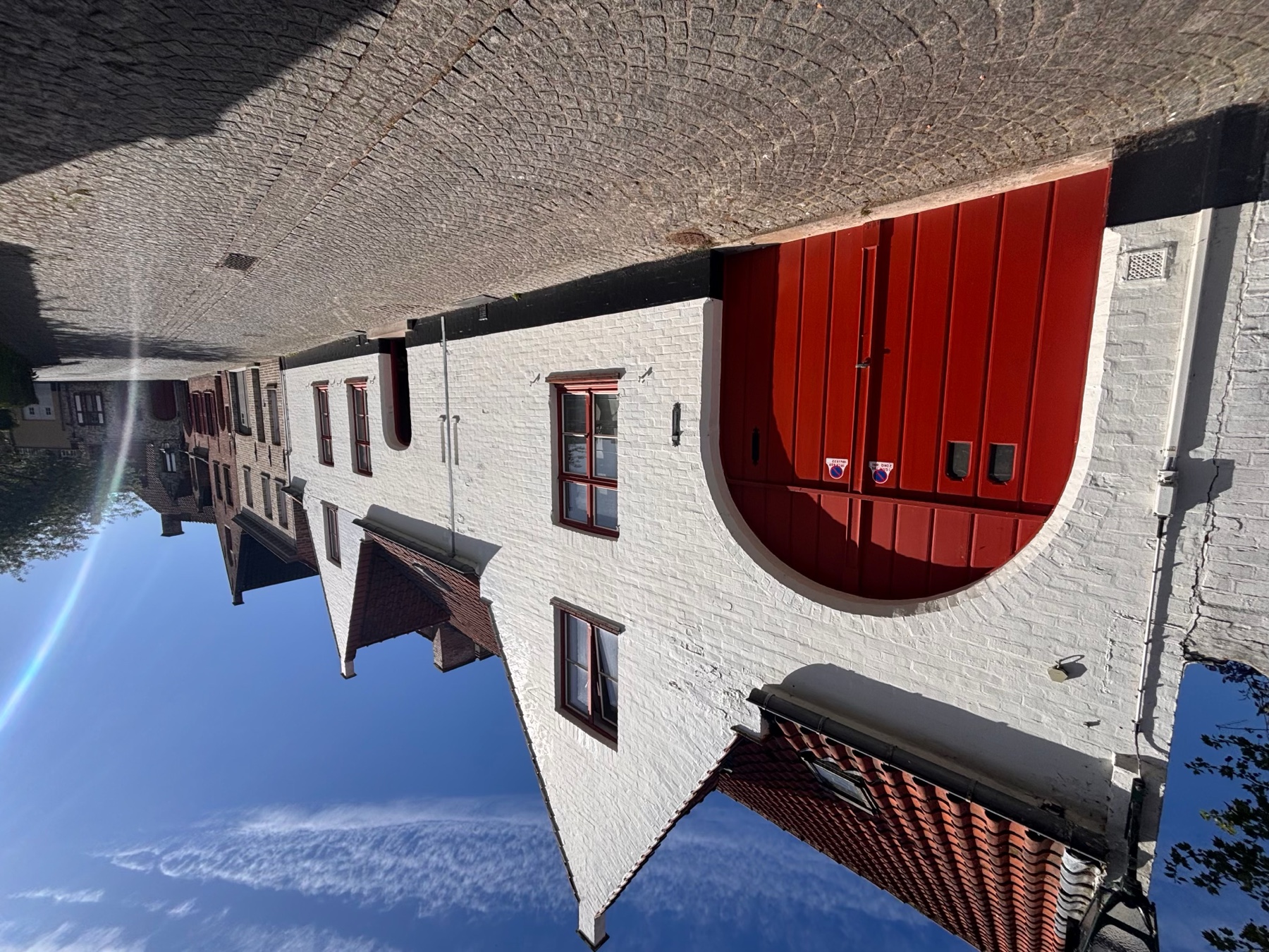 De Speystraat met kasseien en witte gevels, de rode garagepoort links