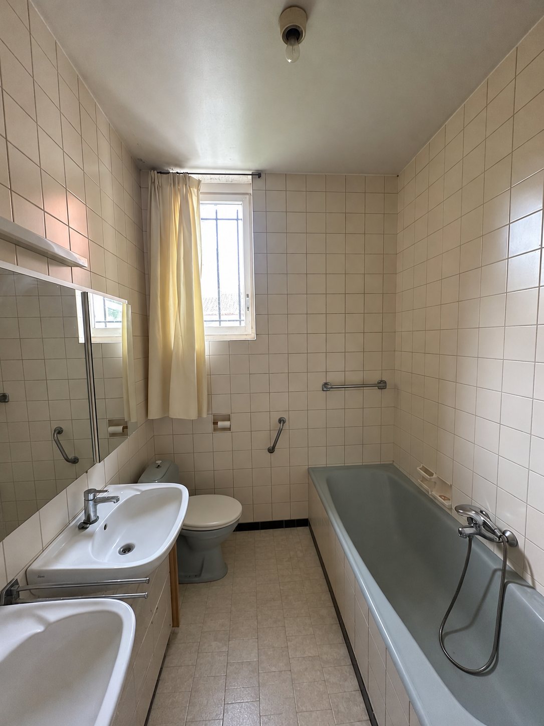 De badkamer met bad, wastafel en toilet
