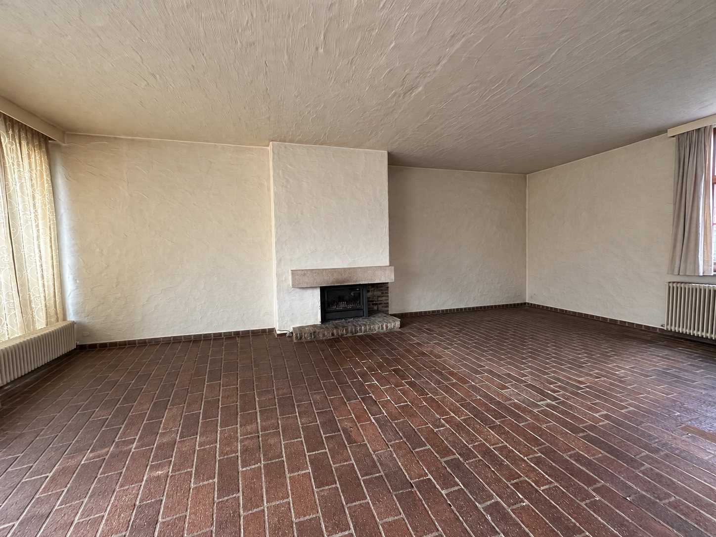 De lege living met haard en baksteenvloer