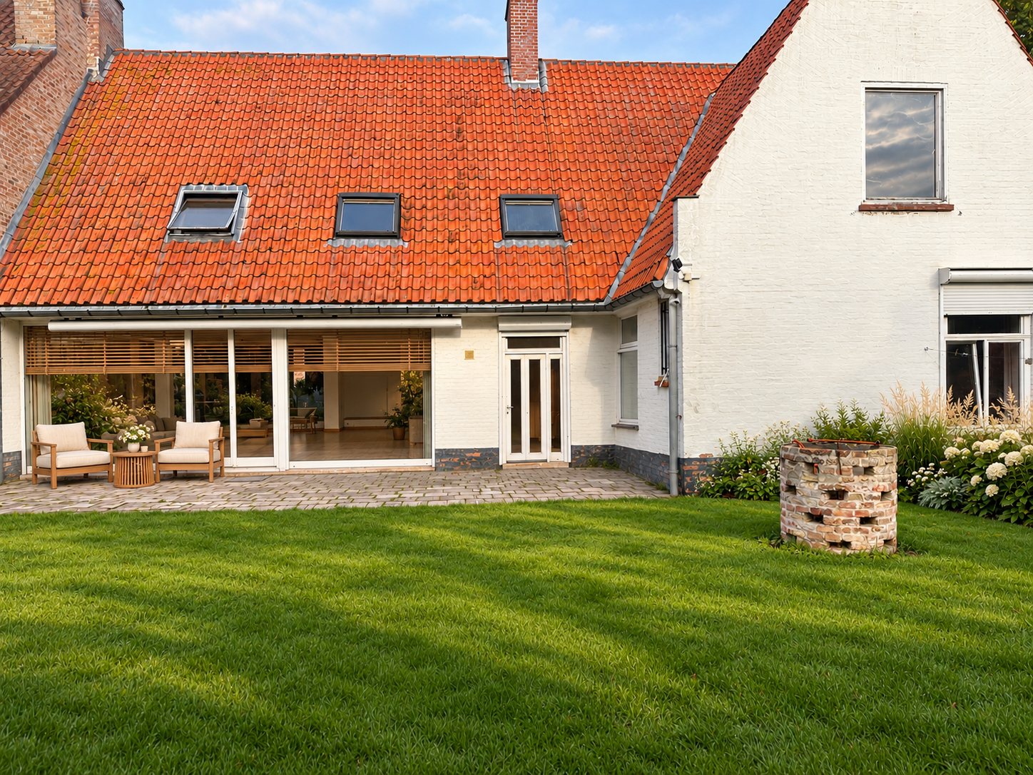 Dezelfde achtergevel met loungehoek op het terras