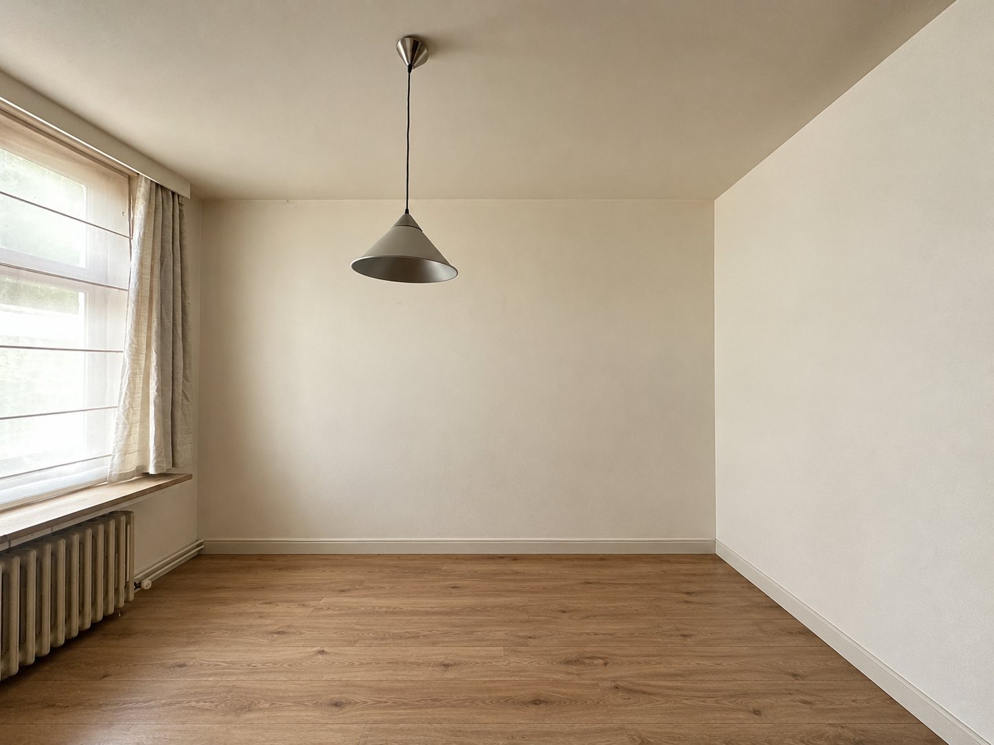 Het lege bureel aan de straatzijde met groot raam en radiator